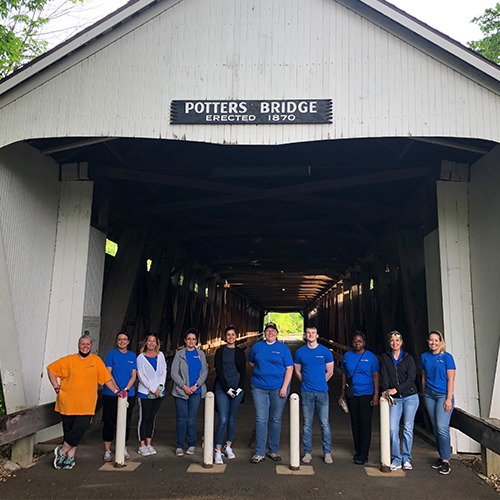 CFB employees volunteering for Hamilton County Parks standing in front of Potter's Bridge in Noblesville.